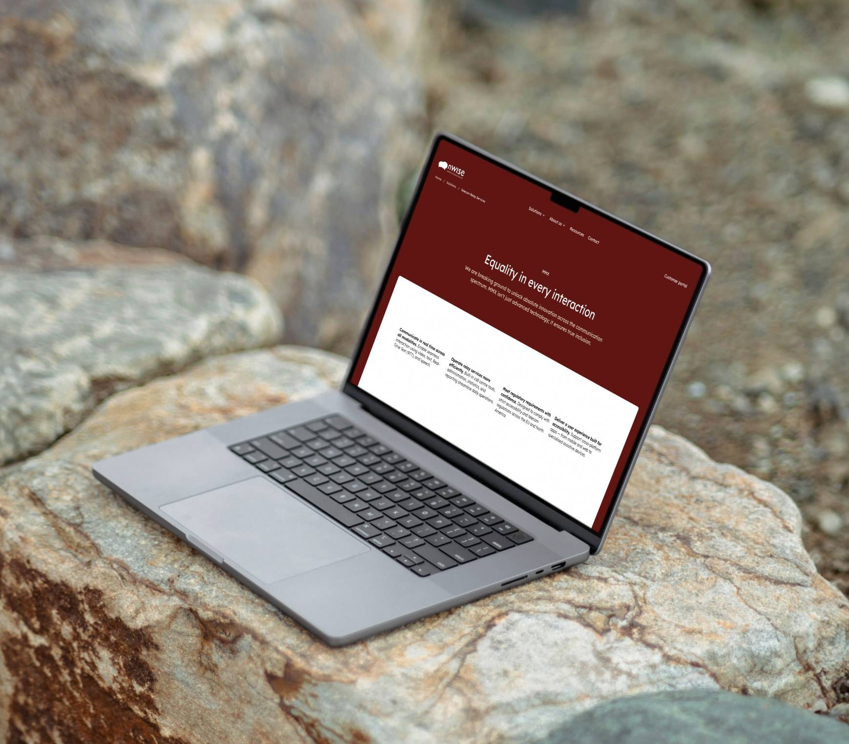 A laptop open on a rock outdoors, showing the nWise MMX product page headed 'Equality in every interaction'.